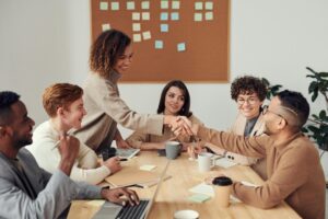 Two employees doing a handshake at a meeting
