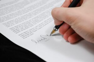 Close-up of a person signing a document