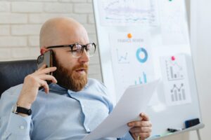 Man talking on the phone while holding documents