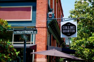 A business signage next to green street signs