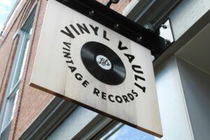 A wooden sign showing a vinyl store’s name